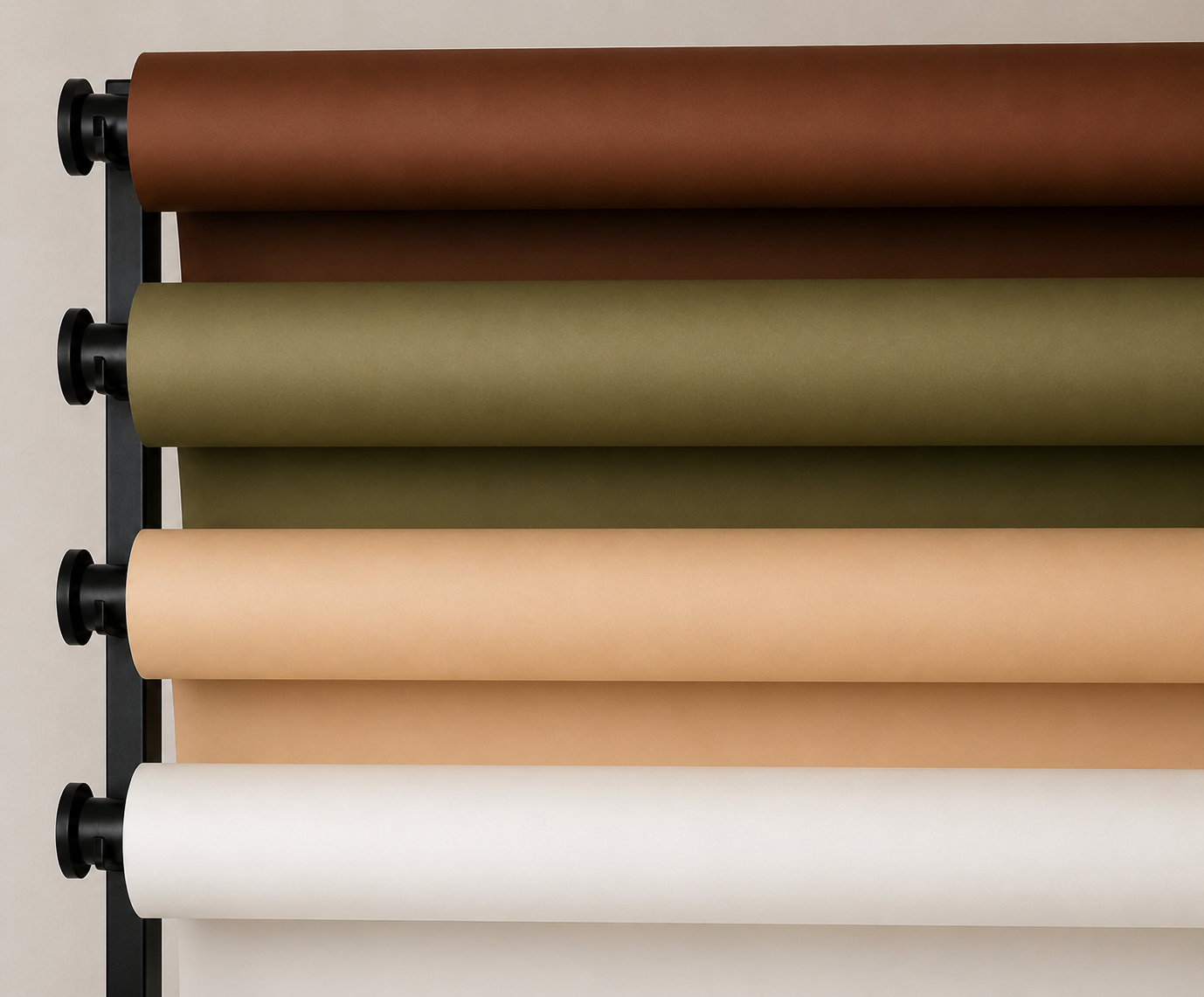 Papier-Hintergrundrollen in verschiedenen Farben – Weiß, Beige, Oliv und Braun – auf einem Wandsystem im Loft-Studio